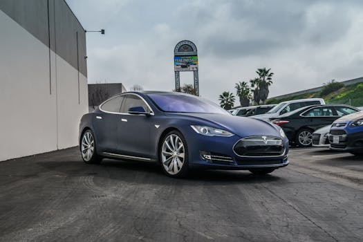 A sleek navy blue Tesla Model S electric vehicle parked in an urban setting.