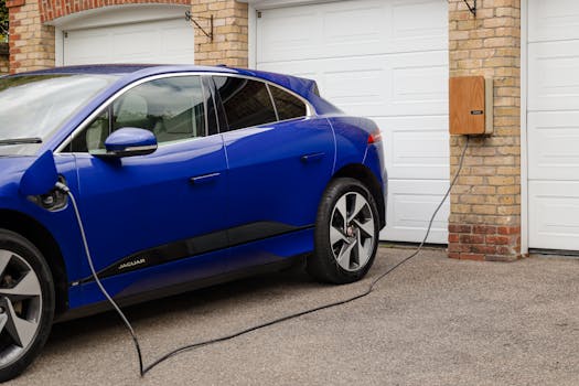 Blue electric vehicle charging at home using wall-mounted unit. Sustainable transportation solution.