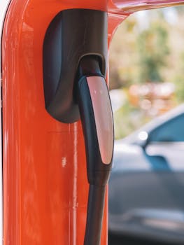 Close-up of an electric car charging station with blurred vehicle in the background.