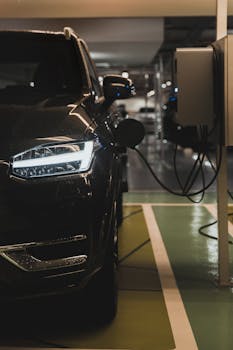 Luxury electric car charging at a station in Curitiba parking garage.